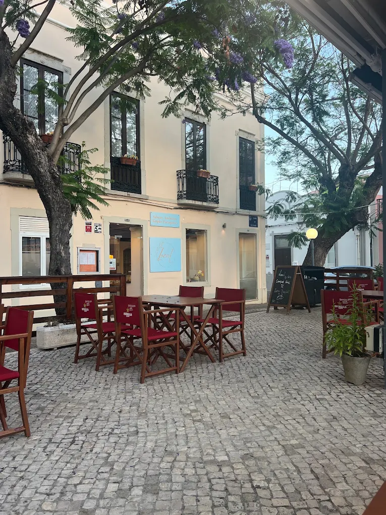 Fachada do Local by Góis no Largo de São Pedro, em Faro, com a esplanada à sombra das jacarandás